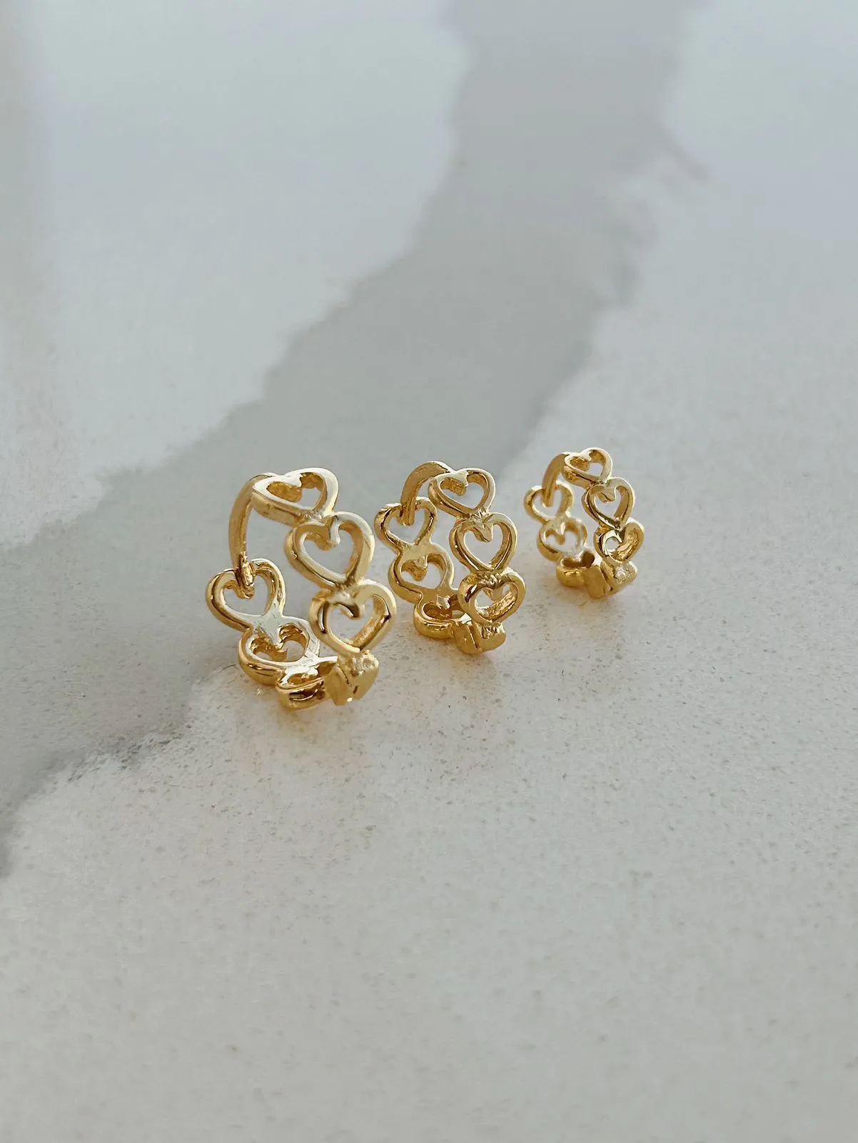 BRINCO ARGOLA COM CORAÇÕES VAZADOS. TAMANHO M. BANHADO A OURO 18K.