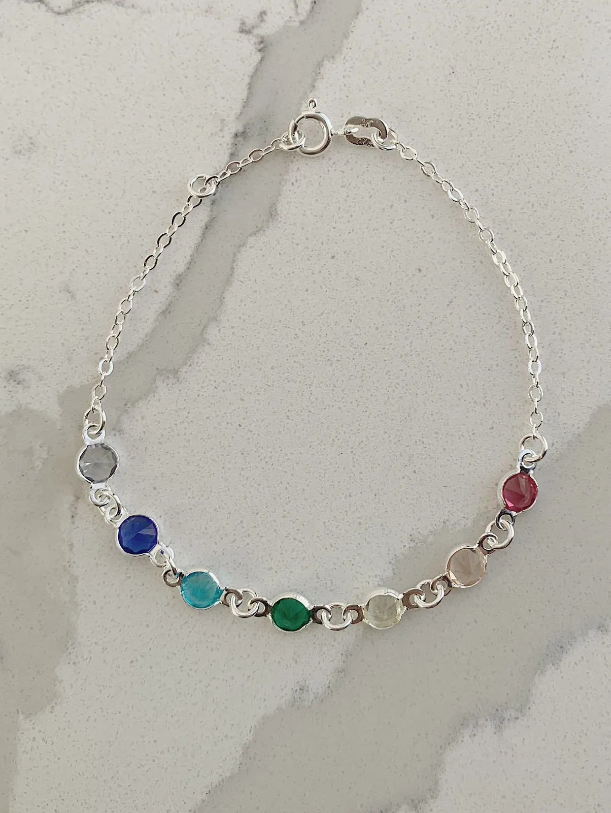 PULSEIRA COM 7 ZIRCÔNIAS COLORIDAS. 18CM DE COMPRIEMENTO E 1CM DE REGULAGEM. EM PRATA 925.