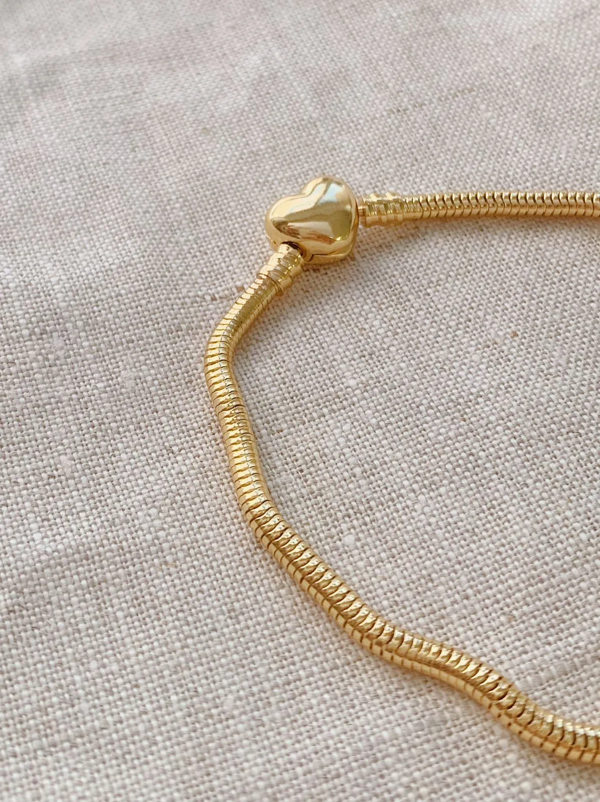 PULSEIRA MOMENTOS DOURADA MALEÁVEL COM FECHO DE CORAÇÃO. BANHADA A OURO 18K.