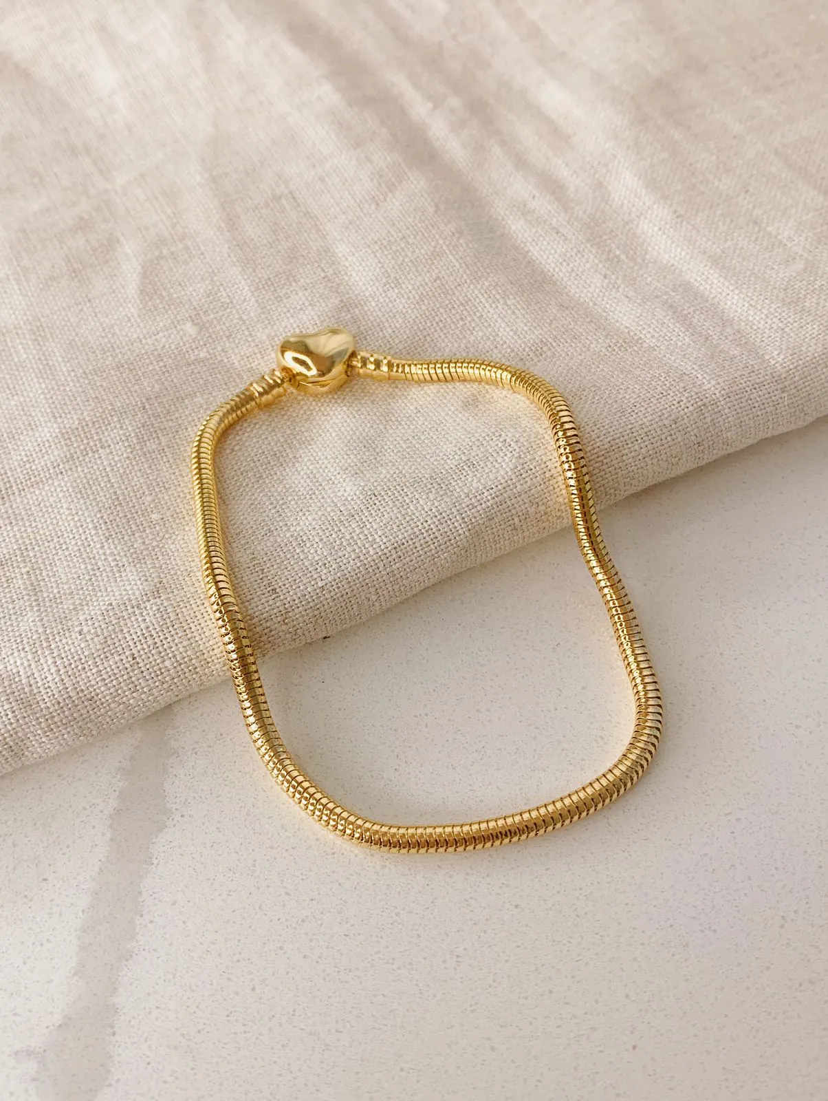 PULSEIRA MOMENTOS DOURADA MALEÁVEL COM FECHO DE CORAÇÃO. BANHADA A OURO 18K.