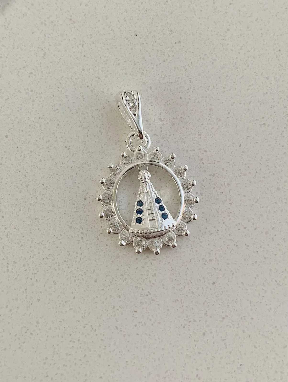 PINGENTE NOSSA SENHORA COM ARO CRAVEJADO E DETALHE AZUL. EM PRATA 925.