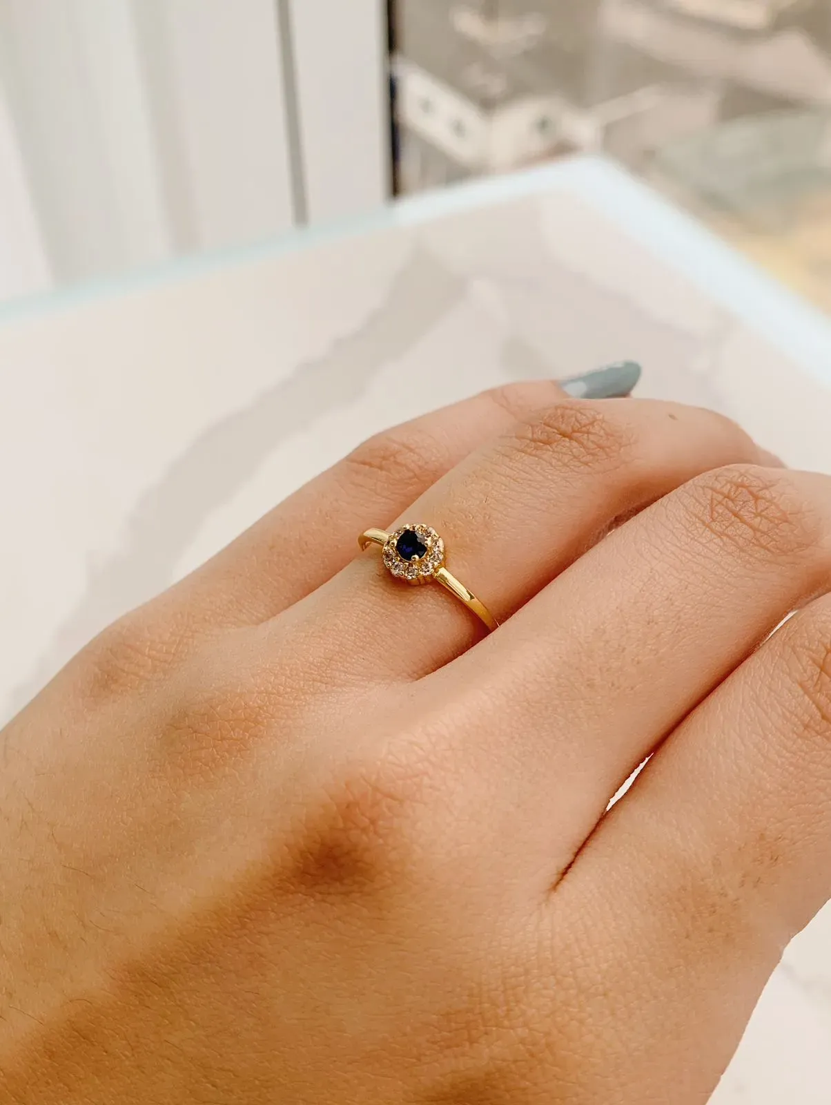 ANEL PEDRA AZUL COM BORDA CRAVEJADA. BANHADO A OURO 18K.