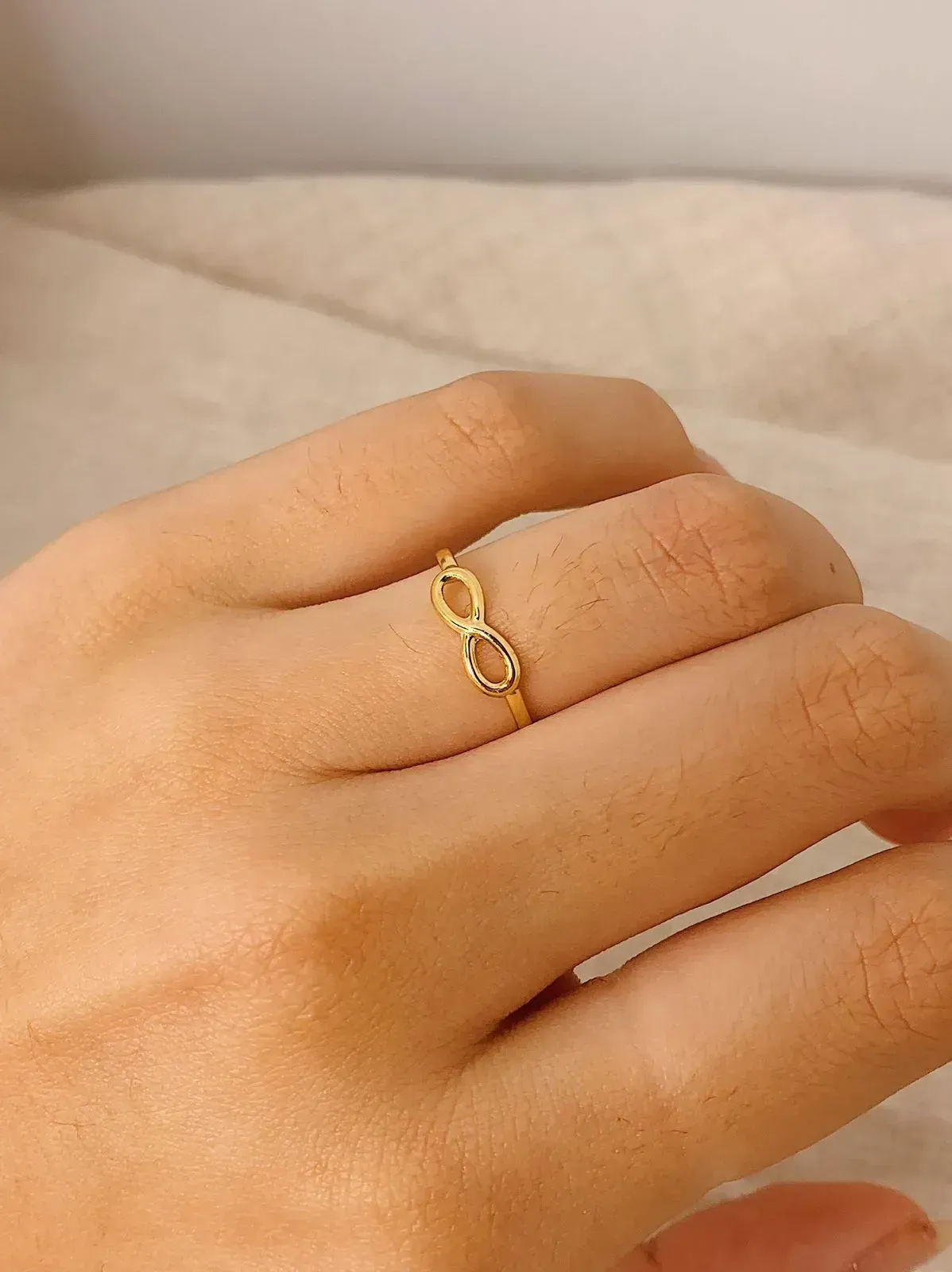 ANEL COM SÍMBOLO DO INFINITO. BANHADO A OURO 18K.