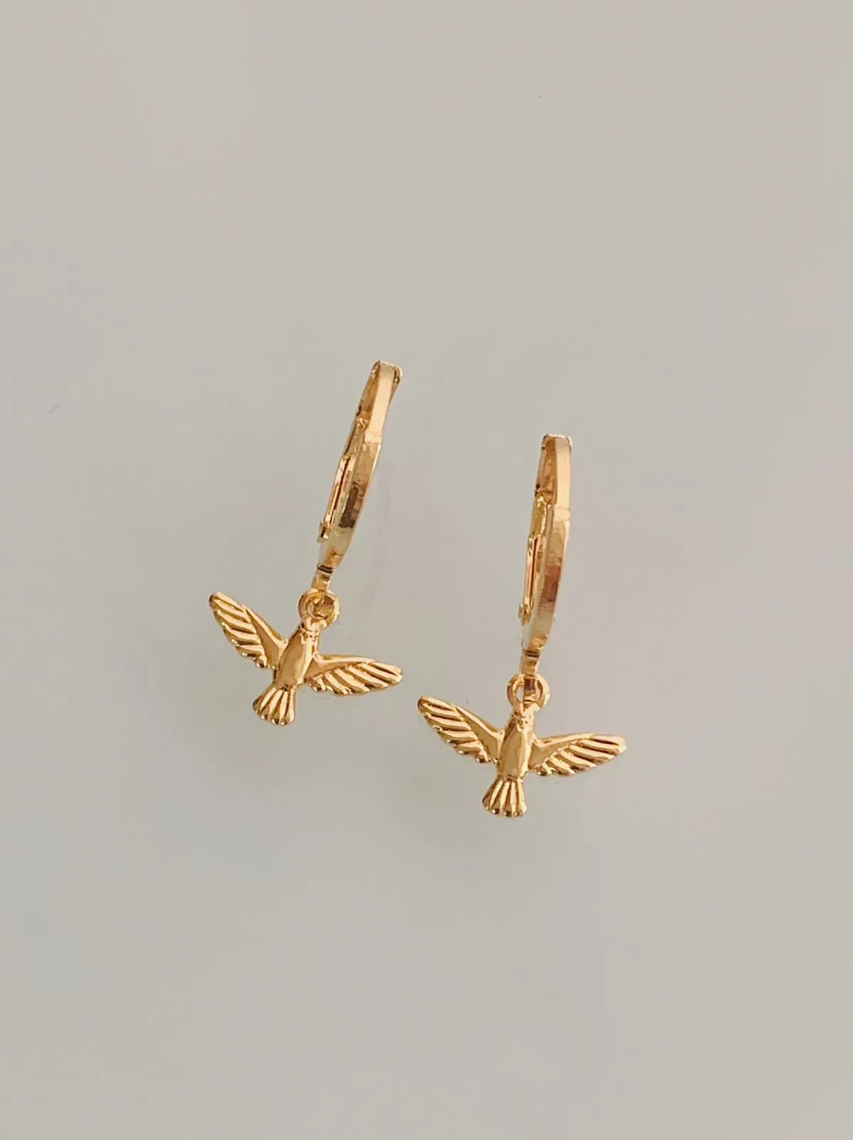 BRINCO ARGOLA COM PINGENTE DE ESPÍRITO SANTO. BANHADO A OURO 18K.