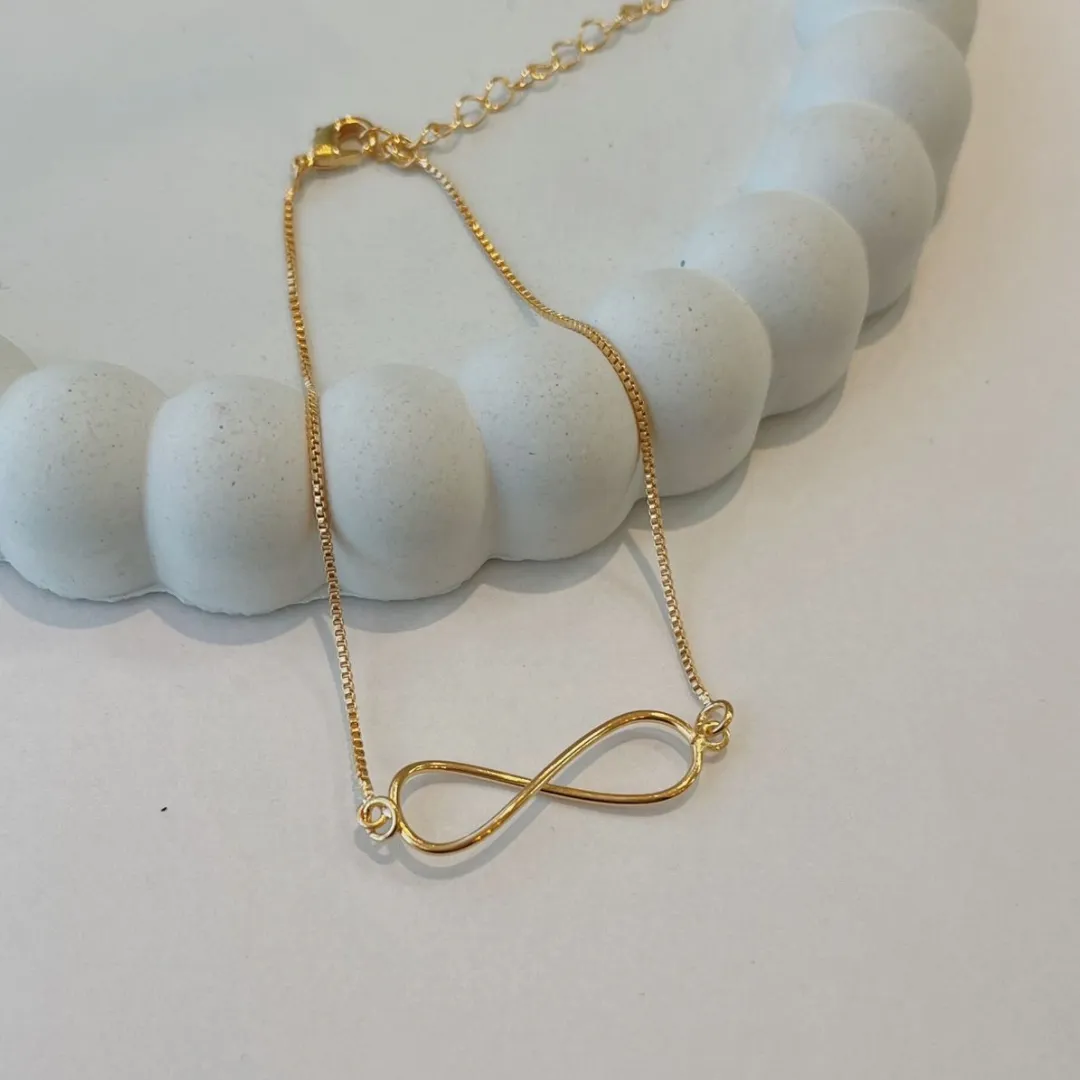 PULSEIRA INFINITO MINIMALISTA. 18CM DE COMPRIMENTO E 5CM DE REGULAGEM. BANHADO A OURO 18K.