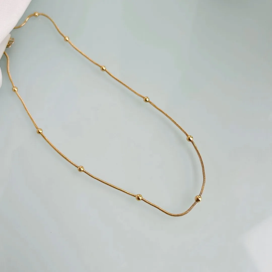 CHOKER BOLINHAS COM FIO RABO DE RATO. 35CM DE COMPRIMENTO E 5CM DE REGULAGEM. BANHADO A OURO 18K.