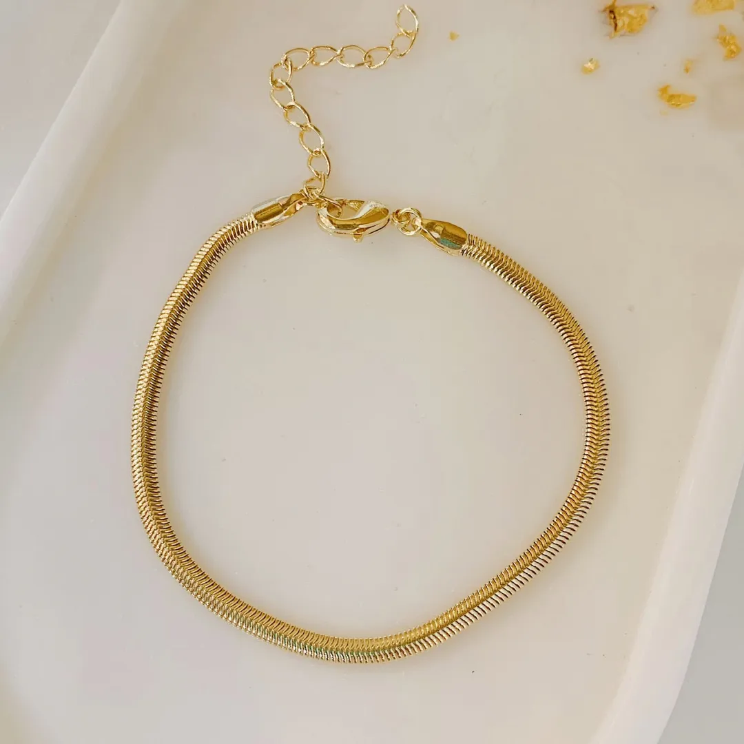 PULSEIRA SNAKE COM 3MM DE ESPESSURA. 16CM DE COMPRIMENTO E 5CM DE REGULAGEM. BANHADO A OURO 18K.