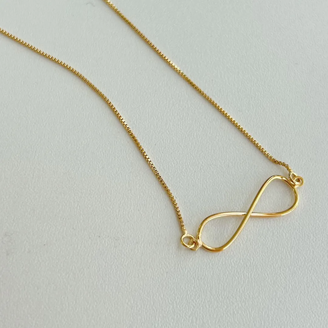 COLAR SÍMBOLO DO INFINITO. 45CM DE COMPRIMENTO E 10CM DE COMPRIMENTO. BANHADO A OURO 18K.