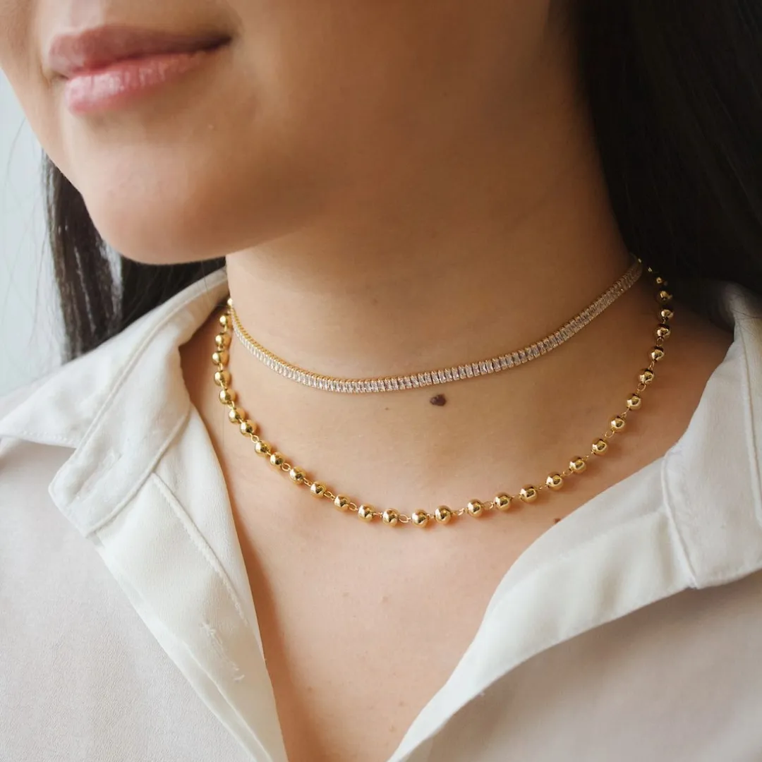 CHOKER ESFERAS. 35CM DE COMPRIMENTO E 10CM DE REGULAGEM. BANHADA A OURO 18K.