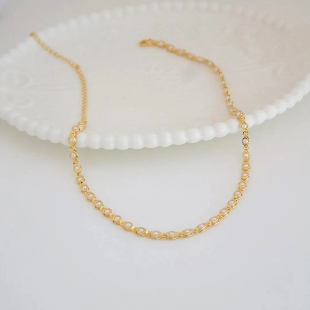 CHOKER PÉROLA COM PLAQUINHA TEXTURIZADA. 35CM DE COMPRIMENTO E 10CM DE REGULAGEM. BANHADA A OURO 18K.